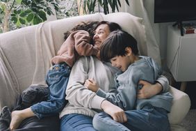 Mom Hugging her two children on the couch 